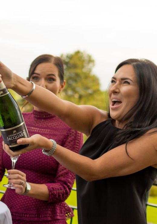 Woman Popping Bottle of Champagne